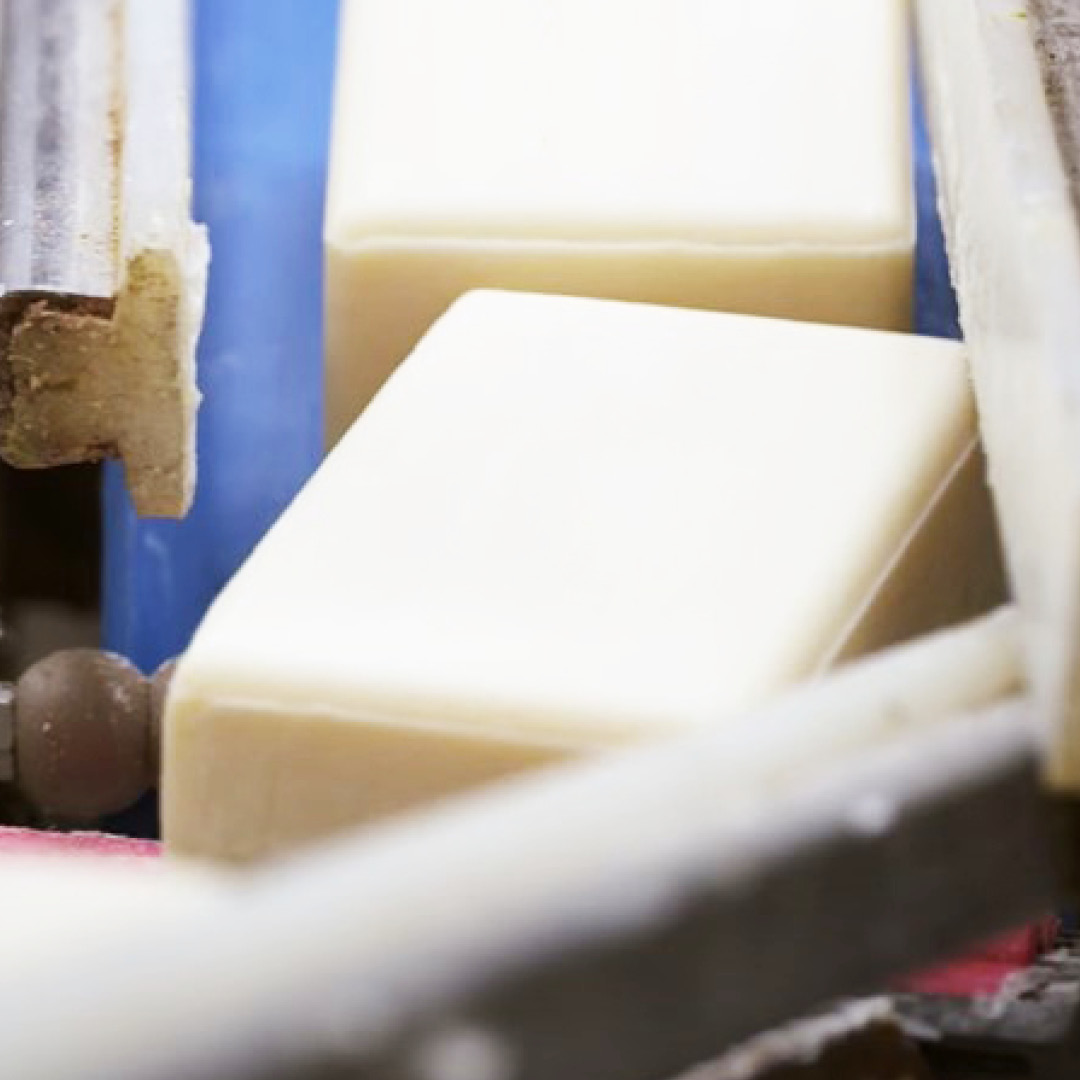 Solid personal care bar moving through manufacturing equipment during production.